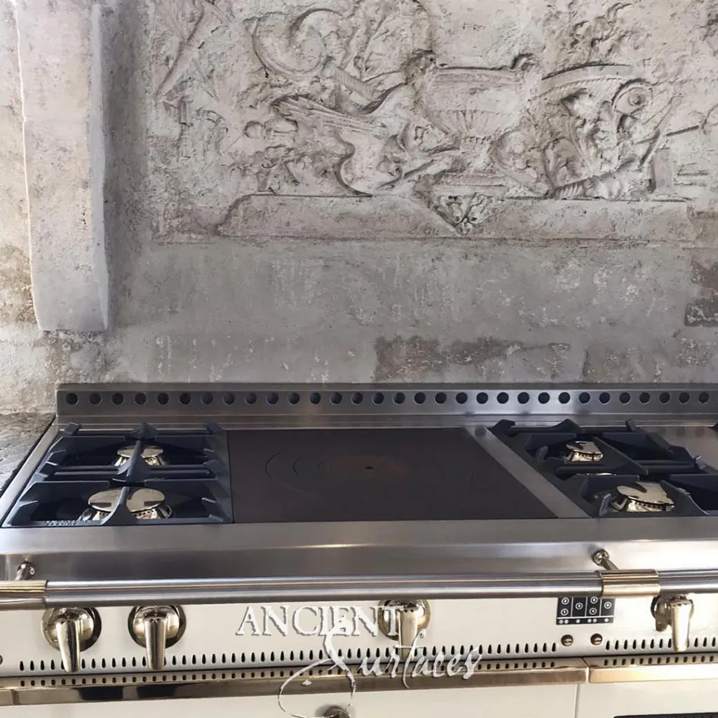 Relief of urns and scrolling foliage carved in stone above a kitchen range, a detail of a carved stone hood